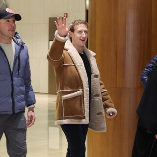 Mr. Zuckerberg, wearing in a tan shearling jacket, waves toward photographers. 