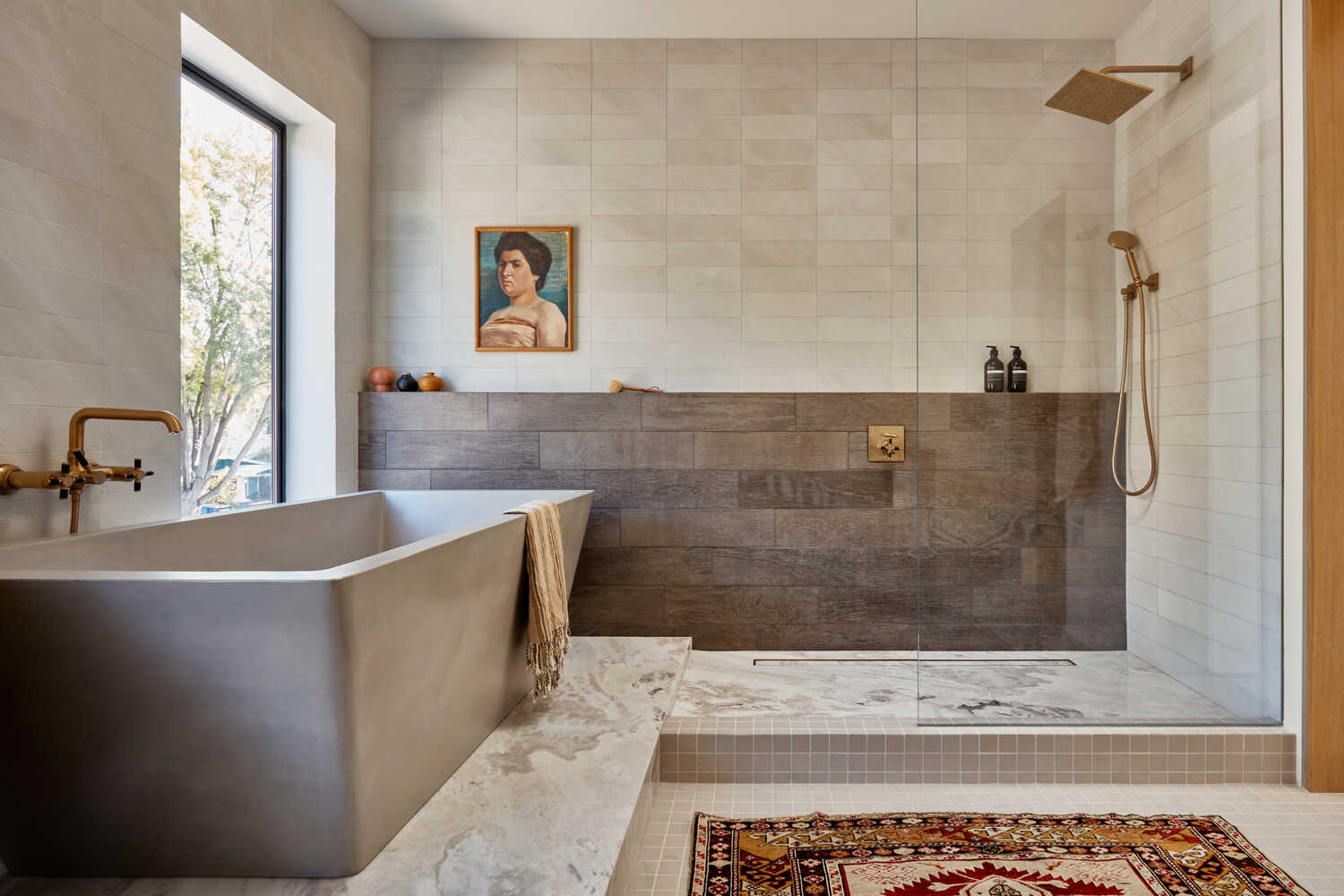 A bathroom with separate tub and shower, with nearly invisible glass shower barrier.